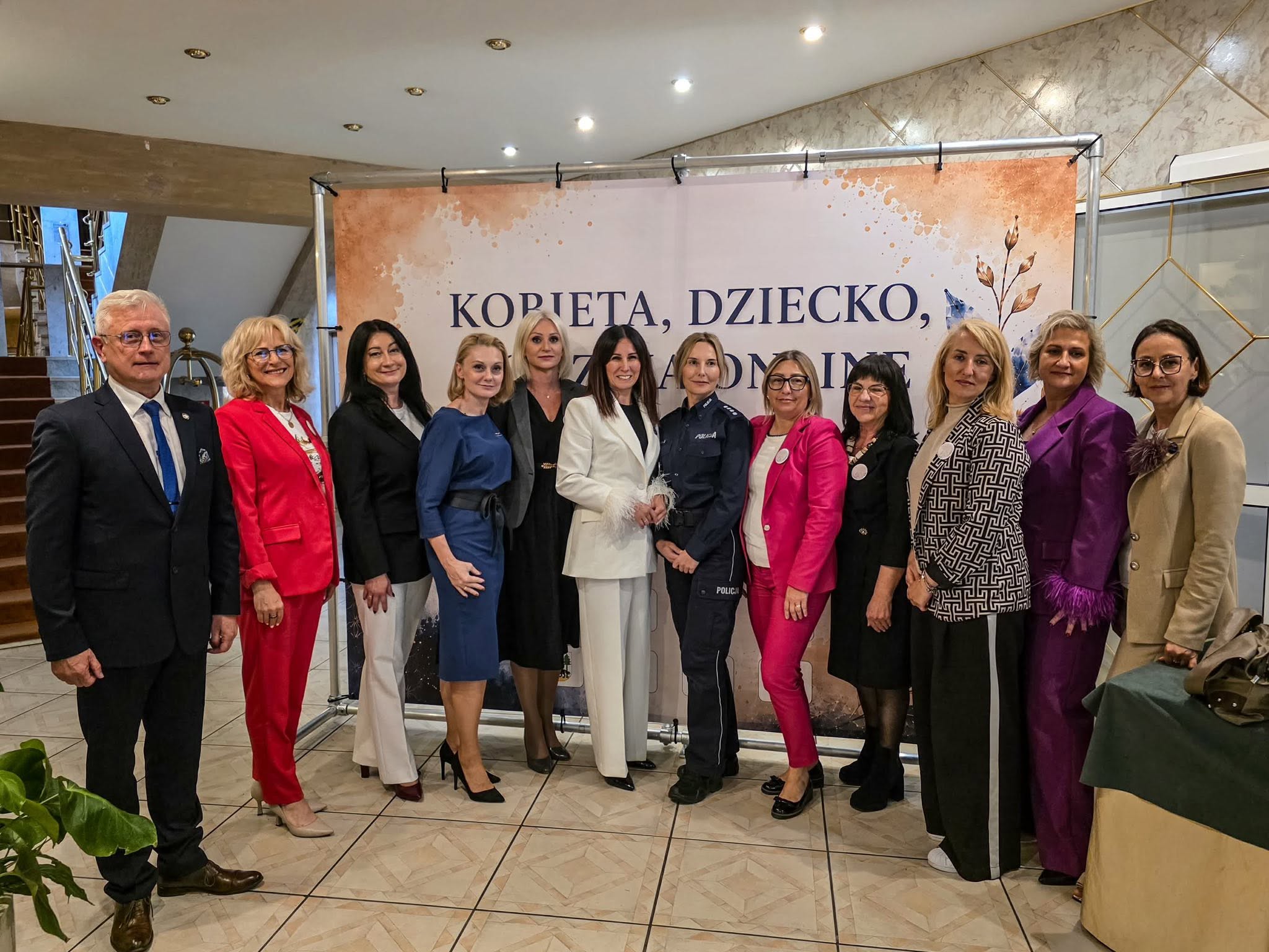 Grupa kobiet i mężczyzn pozuje do zdjęcia.